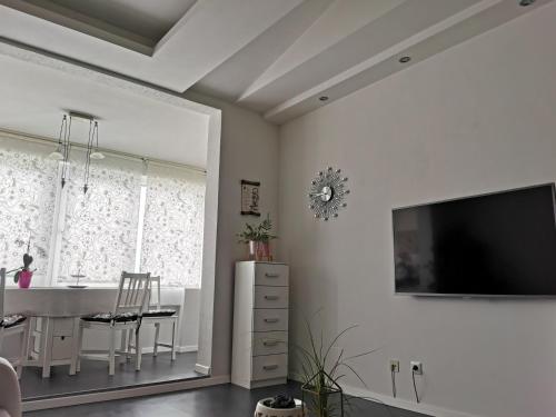 a dining room with a table and a tv on a wall at Apartment Orchidee in Pula