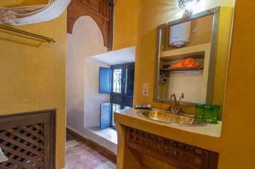 un baño con lavabo y espejo en Riad Ayada, en Marrakech
