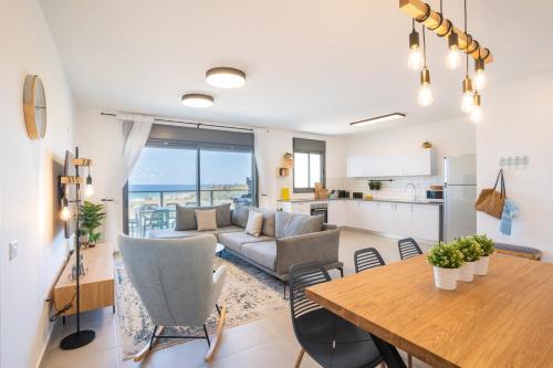 eine Küche und ein Wohnzimmer mit einem Tisch und einem Sofa in der Unterkunft Beach Apartment in Achziv with Incredible Sea Views by Sea N' Rent in Naharija