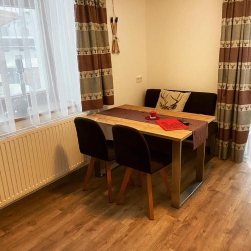 a table and chairs in a room with a window at Rimls Landhaus in Sölden