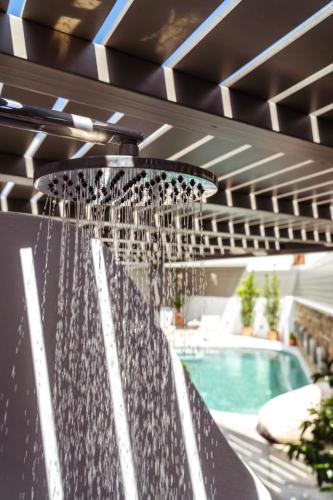 a water fountain in front of a swimming pool at Lithos Luxury Suites in Tinos Town