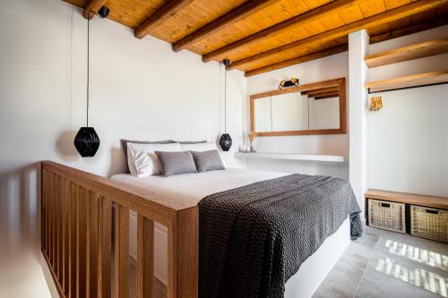 a bedroom with a bed in a room with wooden ceilings at Shizen Houses in Serifos Chora