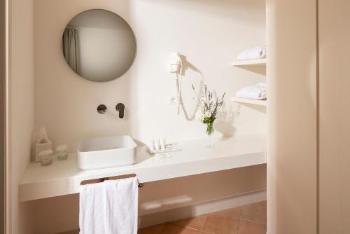 a white bathroom with a sink and a mirror at Giotto Country House & Spa in Assisi