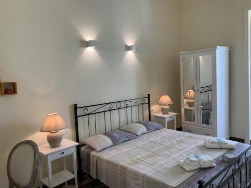 um quarto com uma cama grande com 2 mesas e 2 candeeiros em Piazza Fontana Luxury em Galatina