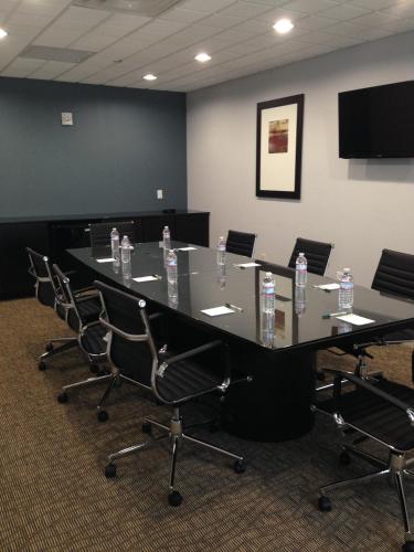 a conference room with a long table and chairs at Wingate Slidell New Orleans in Slidell