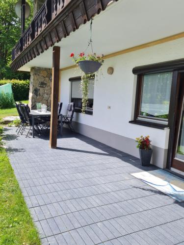 a patio of a house with a table and chairs at FEWO Paternoster in Regen