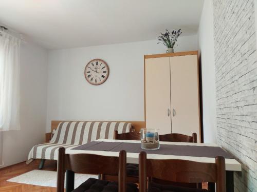 comedor con mesa y reloj en la pared en Apartment Nina, en Rovinj