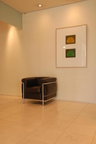 a black leather couch in a room with a painting at 7 Days Hotel in Kochi