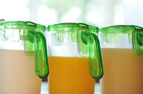 a row of plastic cups filled with different colored drinks at 7 Days Hotel Plus in Kochi