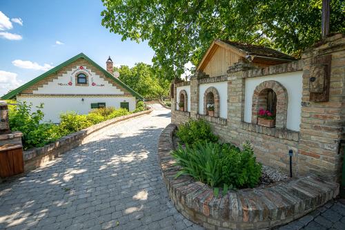 a brick road next to a building with a house at Provence Birtok in Decs