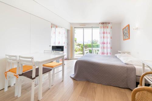 a white bedroom with a bed and a desk at Résidence Le Crystal Dinard Plage in Dinard