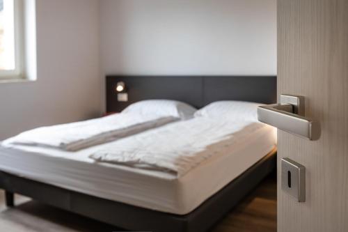 a bed in a room with a open door at Residence Solei Classic & Plus in Brenzone sul Garda