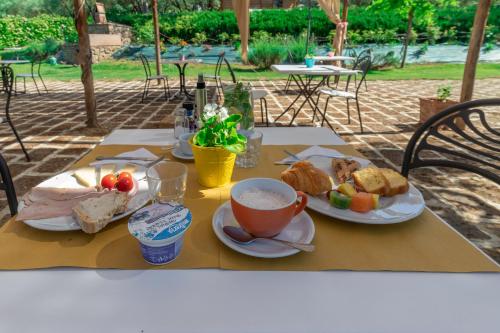 ランポレッキオにあるLa Casa Medioevaleの食べ物の皿とコーヒーカップが置かれたテーブル