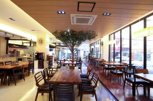 a restaurant with wooden tables and chairs and windows at Towerhill Hotel in Busan