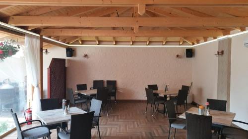 ein Esszimmer mit Holztischen und -stühlen in der Unterkunft PENSIUNE RESTAURANT OVIDIU in Valea lui Mihai