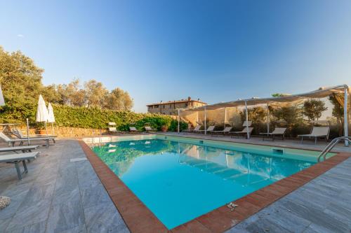 a swimming pool with chairs and a patio at La Casa Medioevale in Lamporecchio