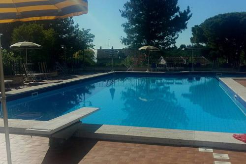 a large blue swimming pool with an umbrella at Residence Vigna del Mare in Gabicce Mare