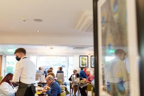 a group of people sitting at tables in a restaurant at Rufford Arms Hotel in Rufford