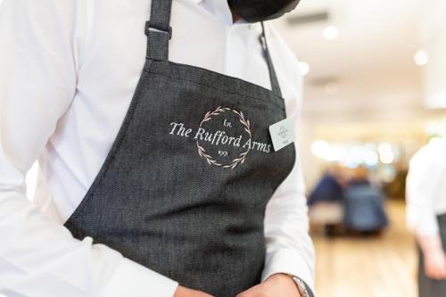 a man in a white shirt and a black apron at Rufford Arms Hotel in Rufford