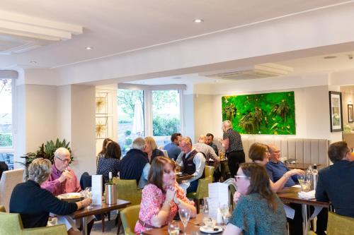a group of people sitting at tables in a restaurant at Rufford Arms Hotel in Rufford