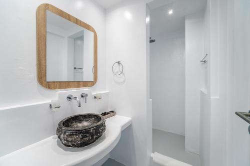 a bathroom with a sink and a mirror at Serenità Luxury Suites in Akrotiri