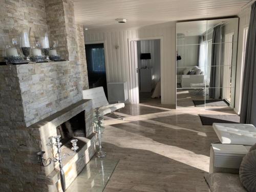 a living room with a stone fireplace and a couch at Villa Terveenniemi in Kontula