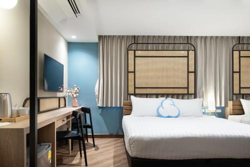 a hotel room with a bed and a desk at The Cotton Saladaeng Hotel in Bangkok