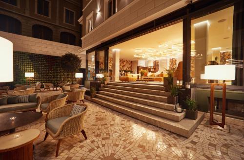 eine Hotellobby mit Stühlen und Tischen in der Unterkunft Radisson Hotel City Centre Odesa in Odessa