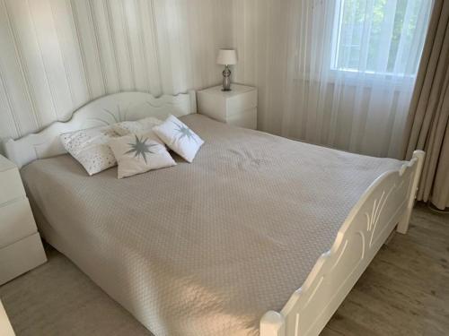 un letto bianco con cuscini sopra di Villa Terveenniemi a Kontula
