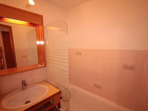 uma casa de banho com um lavatório, um espelho e uma banheira em Studio Les Saisies, 1 pièce, 4 personnes - FR-1-293-146 em Les Saisies