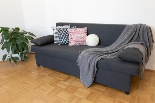 a gray couch with pillows on it in a living room at Yeshello Apartment near Central Station in Vienna