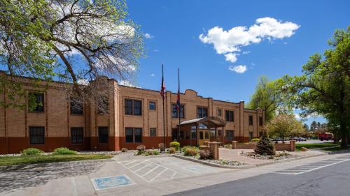 a large brick building with a flag in front of it at Best Western Plus Plaza Hotel in Thermopolis