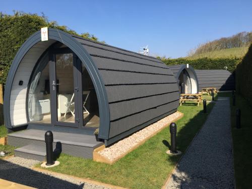 a circular house with a grey roof on the grass at Low Greenlands Holiday Park - Luxury House & Luxury Glamping Pods in Lancaster