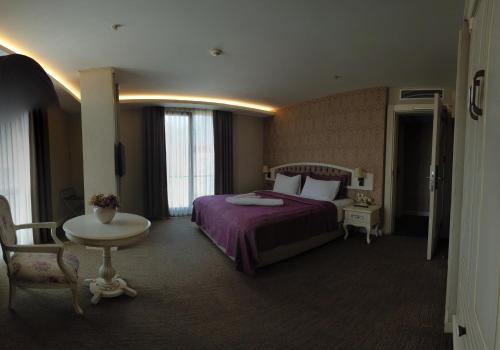 a hotel room with a bed and a table at Hanzade Park Hotel in Trabzon