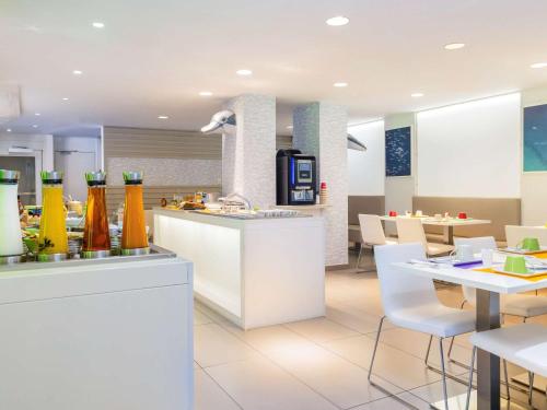 a restaurant with a counter and a table and chairs at Ibis Styles Menton Centre in Menton