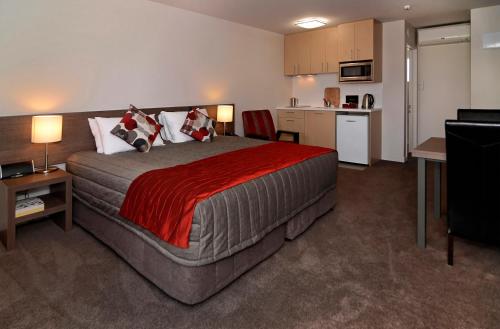 a bedroom with a large bed and a kitchen at Lincoln Motel in Lincoln