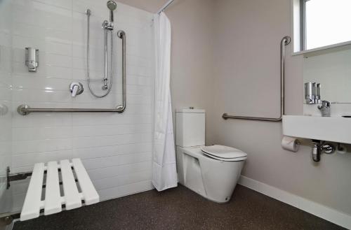 a bathroom with a toilet and a shower and a sink at Lincoln Motel in Lincoln