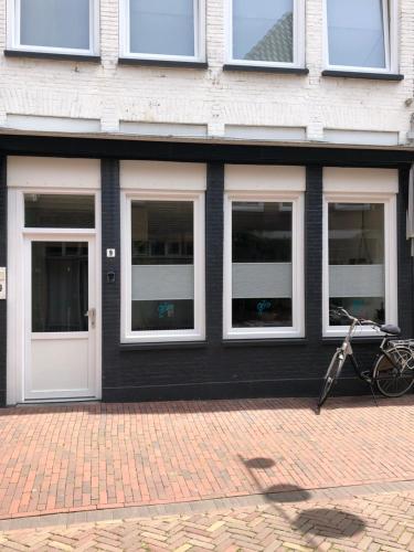 un bâtiment avec quatre fenêtres et un vélo garé à l'extérieur dans l'établissement Centrum Meppel, à Meppel