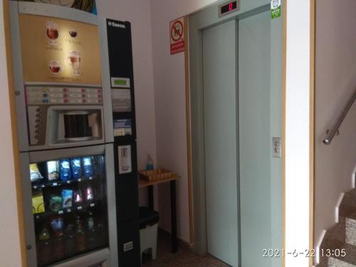 a soda vending machine in a room next to a door at Caminito ARG in La Bañeza