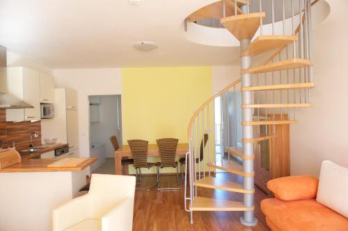 uma escada em espiral numa sala de estar ao lado de uma cozinha em Lipno - Seepark Residence em Horní Planá