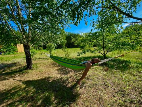 a woman laying in a hammock in a field at Neverland in Zelwa