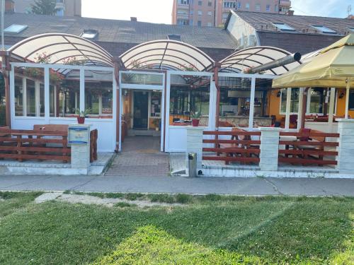 a building with benches in front of it at Kiskakas Étterem in Zalaegerszeg