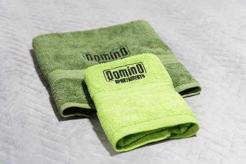 - une serviette verte assise au-dessus du lit dans l'établissement DOMINO-APARTAMENTY Green, à Krościenko nad Dunajcem