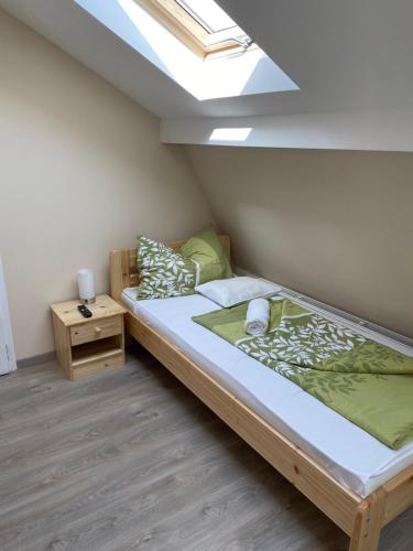a small bedroom with a bed and a skylight at Kiskakas Étterem in Zalaegerszeg
