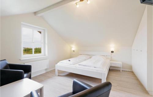ein weißes Schlafzimmer mit einem Bett und 2 Stühlen in der Unterkunft Ferienhaus Dageb�ll 12 in Dagebüll