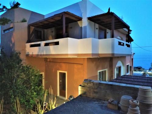 a house with a balcony on top of it at Eutuxia Sea&Mountain Apartment - Tsoutsouros in Tsoutsouros