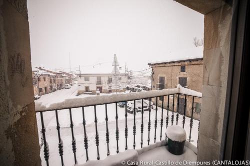 a snow covered balcony with a view of a street at Casa Rural Castillo Diempures in Cantalojas