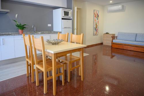 a kitchen with a wooden table and chairs in a room at Albatros Family in Salou