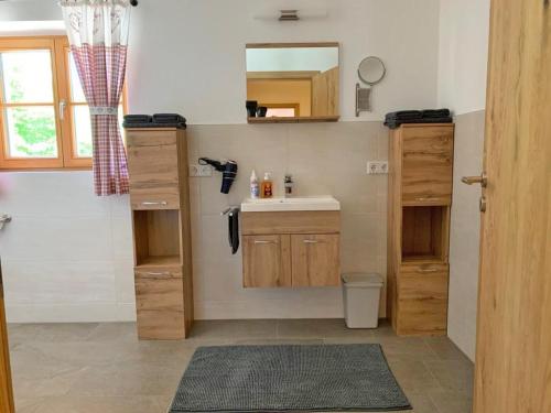 a small bathroom with a sink and a mirror at Ferienwohnungen Kieferbachtal in Kiefersfelden