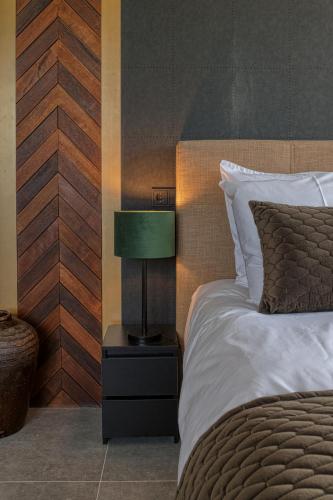 a bedroom with a bed with a green lamp on a night stand at B & B De Elsterberg in Elst